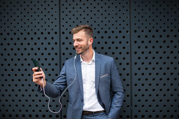 Handsome businessman wearing earphones talking on mobile phone