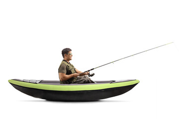 Young man catching fish and sitting in a kayak