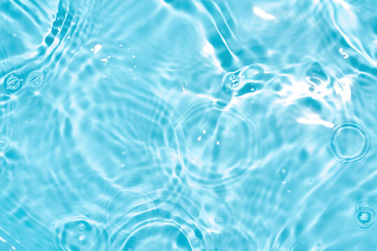 Transparent blue colored clear water surface texture with splashes. Trendy abstract nature background