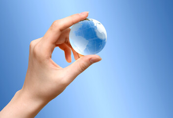 Blue Glass globe of the planet Earth in female hand