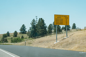 Highway Interstate road sign, alerting truckers and semi drivers to axle weight limitations and...