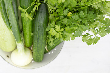 Green vegetables and herbs: onion, coriander, dill and cucumbers Close-up, background