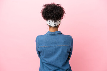 Young latin woman isolated on pink background in back position