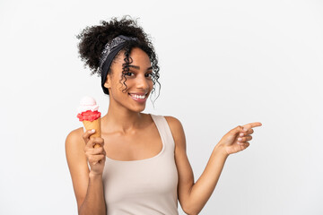 Young african american woman with a cornet ice cream isolated on white background pointing finger to the side