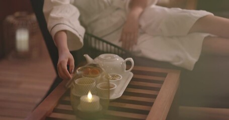 Mindful asian girl in white robe relaxing in oriental spa resort, drinking tea. Elegant woman relaxing, finding inner peace and balance - wellbeing 4k footage
