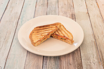 Norwegian salmon sandwich with pickles with sliced bread gratin on a griddle on white plate