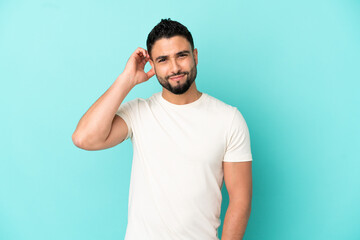 Young arab man isolated on blue background having doubts