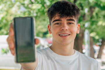 teenage boy showing mobile phone © carballo