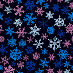 Christmas seamless pattern with complex big and small snowflakes, colored on black background