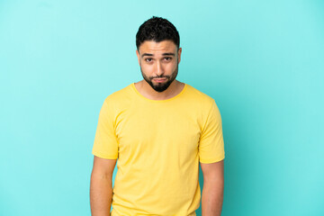 Young arab man isolated on blue background with sad expression