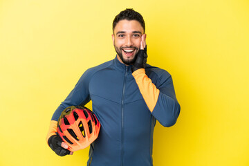 Young cyclist arab man isolated on yellow background with surprise and shocked facial expression