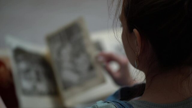 Woman looking at old photo album of her family