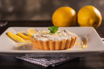 individual lemon tart dessert on wooden background