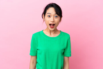 Young Vietnamese woman isolated on pink background with surprise facial expression