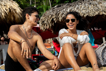 young couple smiling with happiness on the beach during the day