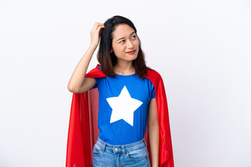 Young Vietnamese woman isolated on white background in superhero costume and having doubts © luismolinero