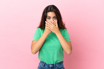 Young caucasian woman isolated on pink background covering mouth with hands