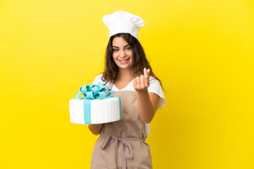 Young caucasian pastry chef woman with a big cake isolated on yellow background making money gesture