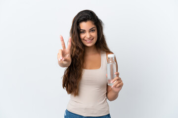 Young caucasian woman with a bottle of water isolated on white background smiling and showing victory sign