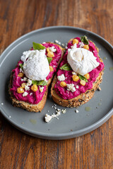 Balinese tasty breakfast with coffee. Toast with hummus and poached egg or scrambled eggs. Hummus from beet.