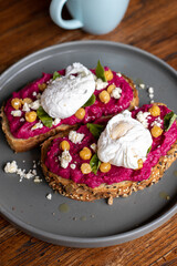 Balinese tasty breakfast with coffee. Toast with hummus and poached egg or scrambled eggs. Hummus from beet.