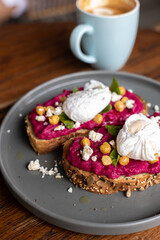 Balinese tasty breakfast with coffee. Toast with hummus and poached egg or scrambled eggs. Hummus from beet.