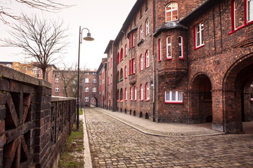 Perspective on the paved street of Nikiszowiec. Brick building. Industrial estate, Katowice, Poland.