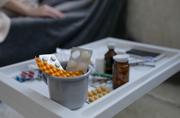 Various drugs and pills on the table at home. Viral pandemic concept. Selective focus