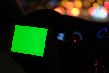 green screen tablet computer in car at night. beautiful bokeh
