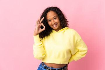 Teenager cuban girl isolated on pink background showing ok sign with fingers