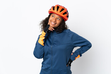 Teenager cyclist woman isolated on white background thinking an idea while looking up