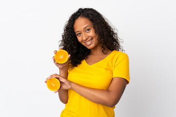 Teenager cuban girl isolated on white background holding an orange