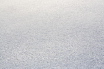 Natural snow texture. Smooth surface of clean fresh snow. Snowy ground. Winter background with snow patterns. Perfect for Christmas and New Year design. Closeup top view.