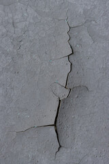 Peeling paint on the wall. Old concrete wall with cracked flaking paint. Weathered rough painted surface with patterns of cracks and peeling. High resolution texture for background and design. Closeup