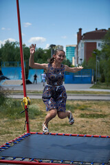 big girl jumping on a trampoline in the park