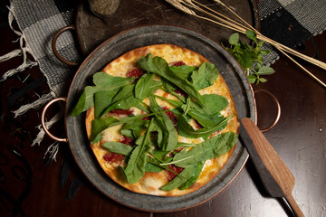 Brazilian pizza with sun-dried tomatoes, arugula and mozzarella