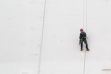 Male worker rope access  inspection of thickness storage tank industry