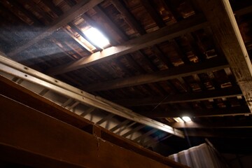 Broken wooden ceiling casting sunlight through a hole. - obrazy, fototapety, plakaty