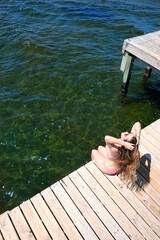 Woman sunbathing on a dock