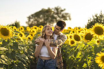 Closeup shot of a Caucasian lovely couple at the sunflowers field in Spain © Miguel Angel Junquera/Wirestock