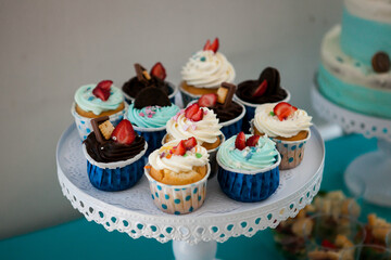 cupcakes with fresh berries and white cream, on a blue background