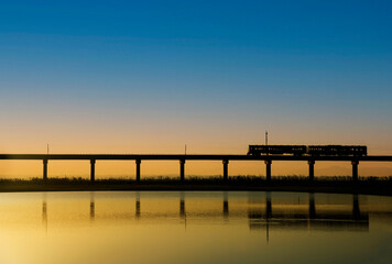 Fototapeta premium Train is running on the railway bridge over the reservoir at Lopburi Thailand