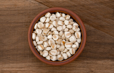 Top view of bowl with white corn for cooking on wooden table background