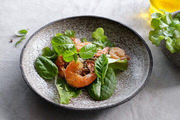Fresh green salad with basil leaves, fried shrimps and lemon. Close up dish with copy space. Top view