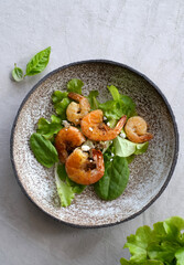 Fresh green salad with basil leaves, fried shrimps and lemon. Close up dish with copy space. Top view