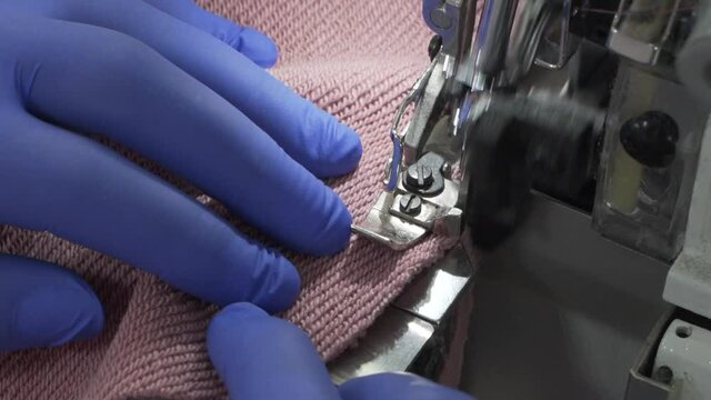 Closeup of sewing process on the overlock in the atelier