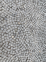 sidewalk, radially paved with small square granite stones. radial pattern. top view.