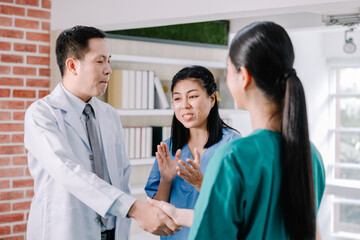 The team of medical personnel shakes hands with joy and smiles and happy expressions, the concept of success in health work young adult surgeon coworker nurse colleague cooperation