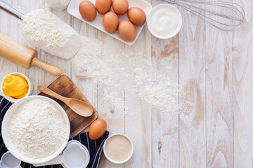 Homemade dough recipe (eggs, flour, milk, sugar) on a wooden table top view. - obrazy, fototapety, plakaty