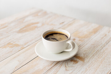 white coffee cup on wooden table with morning light